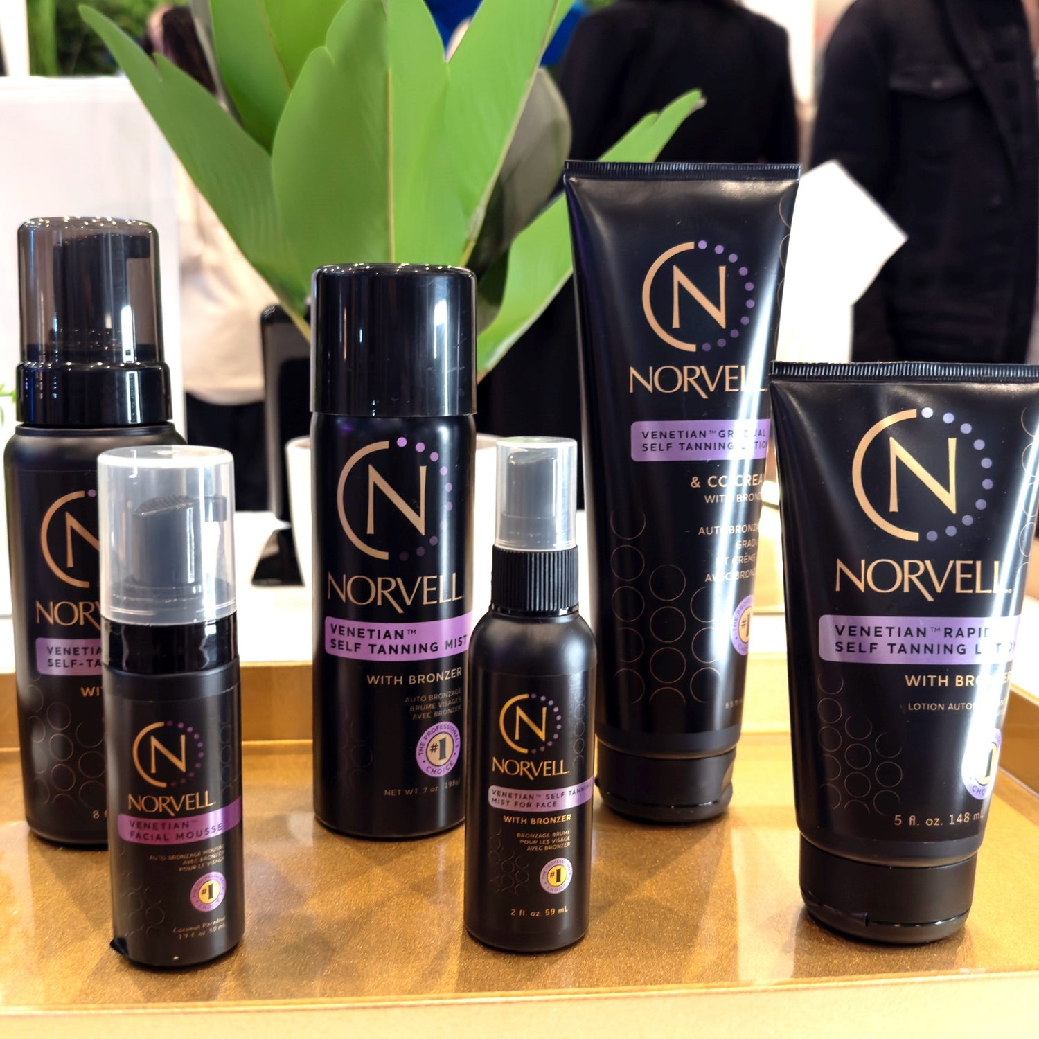 Collection of Norvell self-tanning products on a wooden surface with a blurred background.