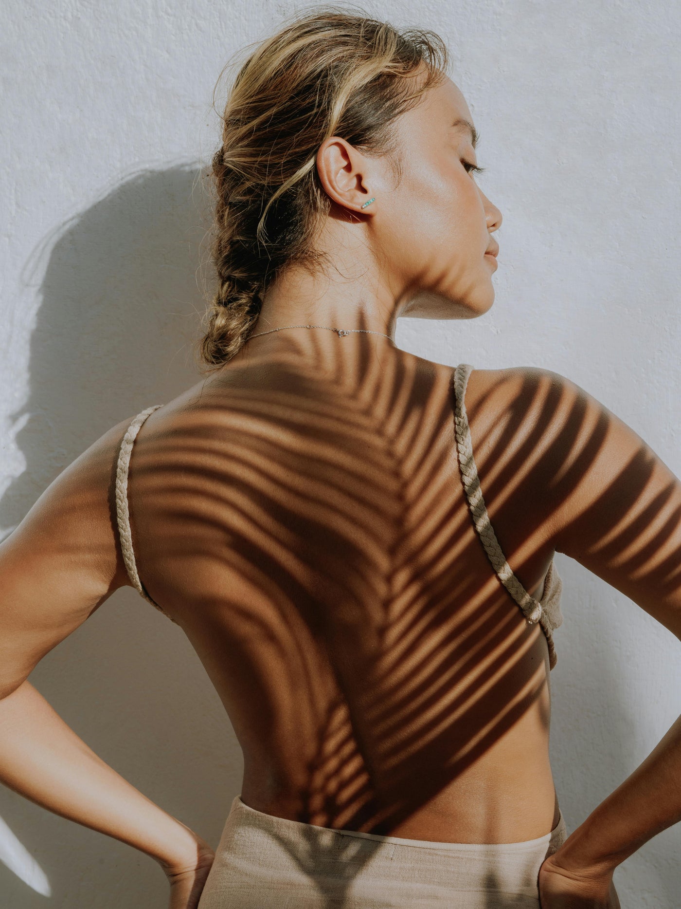 woman with palm leaf shadow on back