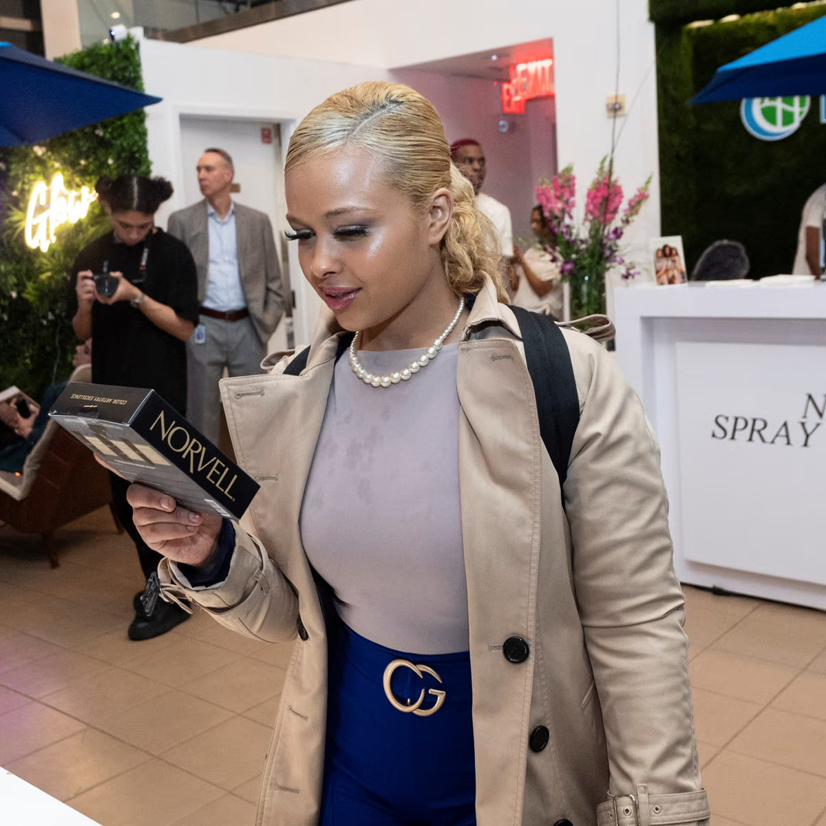 Woman holding a Norvell product in a busy indoor setting