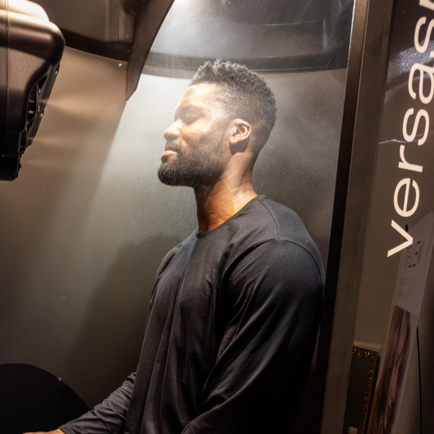 Man in a VersaSpa Pro Booth getting a WellFit treatment